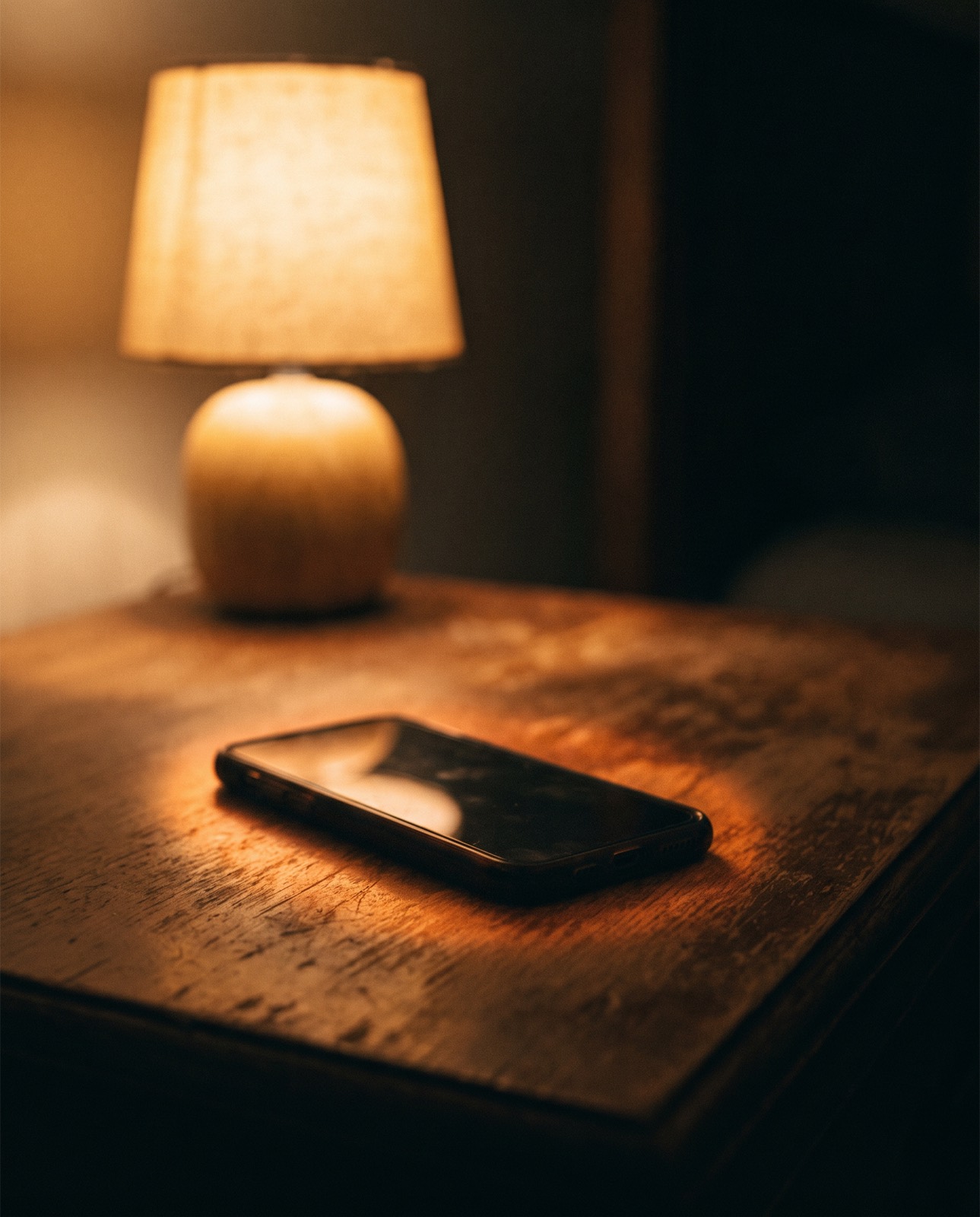 A phone lying face down on a table at night